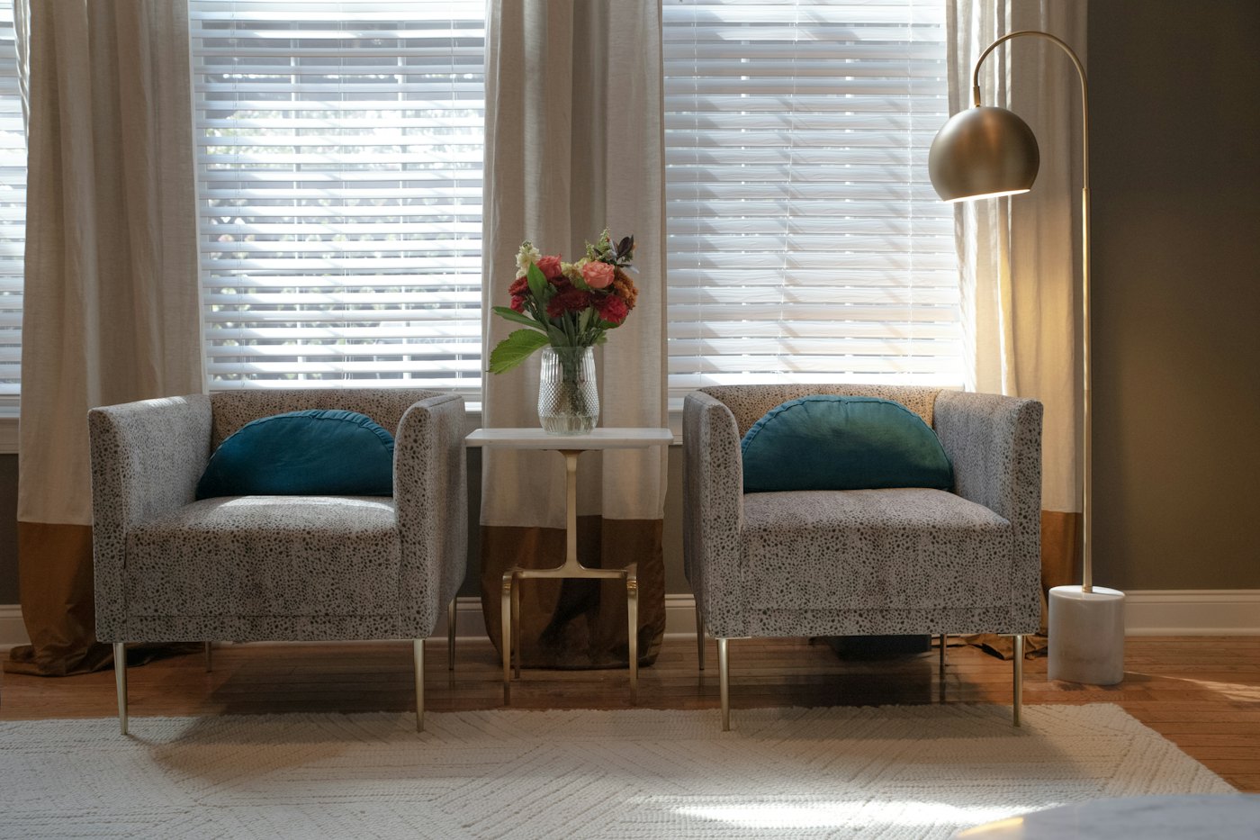 Kaks tugitooli valges toas akna all
